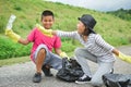 Children hand in yellow gloves picking up empty of bottle plastic into bin bag Royalty Free Stock Photo
