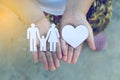 Children hands holding small model of heart and family Royalty Free Stock Photo