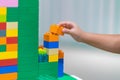 Children hands play with colorful plastic toys blocks on table Royalty Free Stock Photo