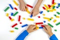 Kids hands playing with colorful building plastic bricks on white background. Educational developing toys background Royalty Free Stock Photo