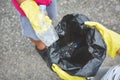 Children hands in yellow gloves picking up empty of bottle plastic into bin bag Royalty Free Stock Photo