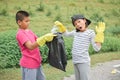 Children hands in yellow gloves picking up empty of bottle plastic into bin bag Royalty Free Stock Photo