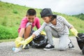 Children hands in yellow gloves picking up empty of bottle plastic into bin bag