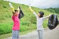 Children hands in yellow gloves picking up empty of bottle plastic into bin bag Royalty Free Stock Photo