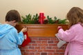 Children Hanging Stockings Over The Fireplace
