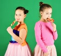 Children with happy faces pose with candies on green background. Royalty Free Stock Photo
