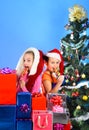 Children with happy faces sit under New Year tree Royalty Free Stock Photo