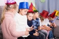 Children happy to play with mobile phones together at dinner Royalty Free Stock Photo