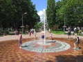 Children have a fun with city fountains in hot summer day