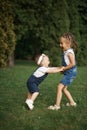 Children have fun holding hands, running and jumping in the park on a summer day Royalty Free Stock Photo