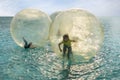 Children have fun inside plastic balloons on the sea Royalty Free Stock Photo