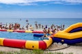 Children have fun on a rubber water slide on the beach in Zaliznyi Port Kherson region.