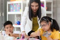 Children have fun during study at school with friends and teacher, girl with down syndrome concentrate on painting hand in art