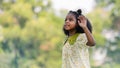 African black child with curly hair is jumping happily in the water spray at outdoor