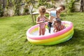 Children Having Fun In Garden Paddling Pool