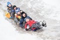 Children having fun riding ice slide in snow winter