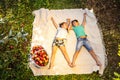 Children having a little picnic in summer garten with apples, spreading on white blanket.