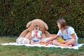 Children having picnic with teddy toys in garden at home Royalty Free Stock Photo