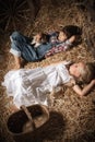 Children in the hay in the barn with a kitten