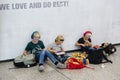 Children with headphones use the tablet sitting on the ground next to their backpacks and puppets