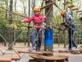 Children in helmets and with equipment climb the cable cars in the forest