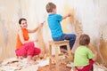 Children help mother remove old wallpapers