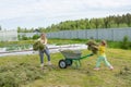 Children help to remove the mown grass from the field.