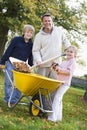 Children helping father to collect autumn leaves