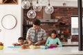 Children Helping Father To Make School Lunches In Kitchen At Home