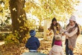 Children Helping Mother To Collect Autumn Leaves In Garden Royalty Free Stock Photo