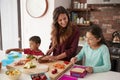 Children Helping Mother To Make School Lunches In Kitchen At Home Royalty Free Stock Photo