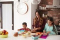 Children Helping Mother To Make School Lunches In Kitchen At Home Royalty Free Stock Photo