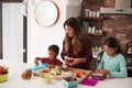 Children Helping Mother To Make School Lunches In Kitchen At Home Royalty Free Stock Photo