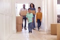 Children Helping Parents To Carry Boxes Into New Home On Moving In Day Royalty Free Stock Photo