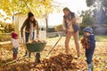 Children Helping Parents To Collect Autumn Leaves In Garden Royalty Free Stock Photo