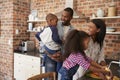 Children Helping Parents To Prepare Meal In Kitchen