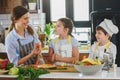 Children helping their mother in the kitchen preparing healthy vegetarian meal. Royalty Free Stock Photo