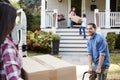 Children Helping Unload Boxes From Van On Family Moving In Day