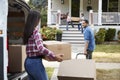 Children Helping Unload Boxes From Van On Family Moving In Day