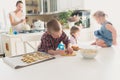 Children with her mother preparing cookies, large family. casua