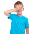 Children, hide and seek and surprise with a boy in studio isolated on a white background covering his face with his hand