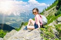 Children hiking on beautiful summer day in alps mountains Austria, resting on rock and admire amazing view to mountain Royalty Free Stock Photo