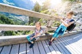 Children hiking on beautiful summer day in alps mountains Austria, resting on rock and admire amazing view to mountain Royalty Free Stock Photo