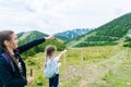 Children hiking on beautiful summer day in alps mountains Austria resting on rock. Kids look at map mountain peaks in Royalty Free Stock Photo