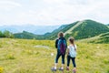 Children hiking on beautiful summer day in alps mountains Austria resting on rock. Kids look at map mountain peaks in