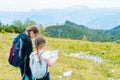 Children hiking on beautiful summer day in alps mountains Austria resting on rock. Kids look at map mountain peaks in Royalty Free Stock Photo