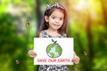 Children hold paper drawing Earth and green seedling growth and word save our Earth with green tree background and butterfly Royalty Free Stock Photo