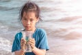 Children holding Plastic cup that he found on the beach for enviromental clean up concept