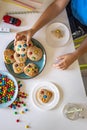 Funny male brothers eat cookies with round multi-colored sweets and drink milk. Top view. Royalty Free Stock Photo