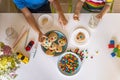 Funny male brothers eat cookies with round multi-colored sweets m&m and drink milk. Top view. Royalty Free Stock Photo